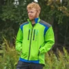 Mann in grüner Forstjacke steht vor einem Wald